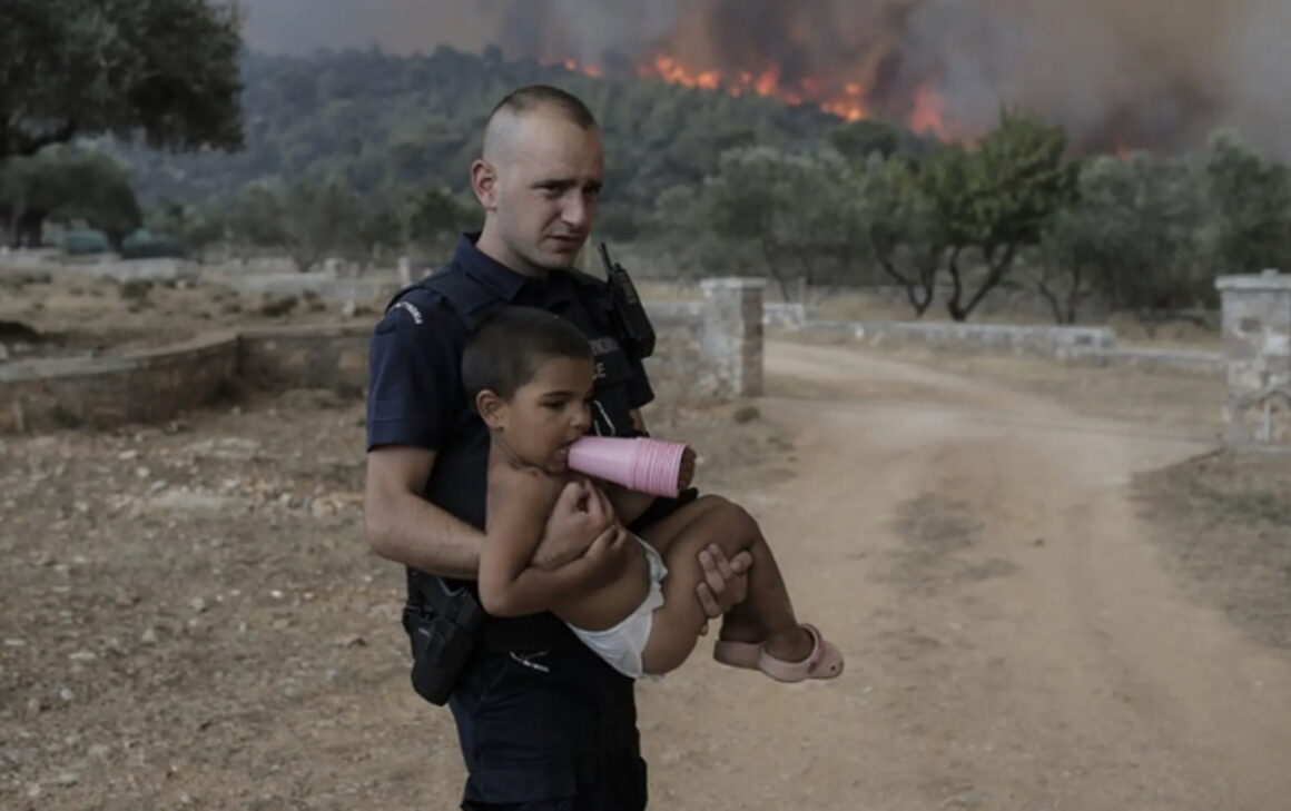 Φωτιά: Πρωτοσέλιδο στα ξένα ΜΜΕ ο αστυνομικός που έσωσε παιδιά στα χέρια από την πυρκαγιά